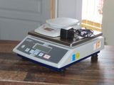 une photo d'une balance numérique posée sur une table en bois