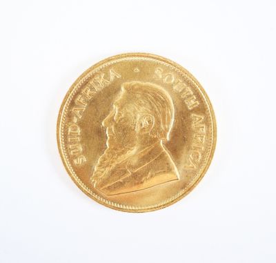gros plan d'une pièce d'or sur une surface blanche