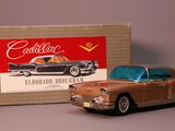 toy car in front of a cardboard box with a picture of a cadillac