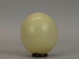 a white egg sitting on top of a wooden stand