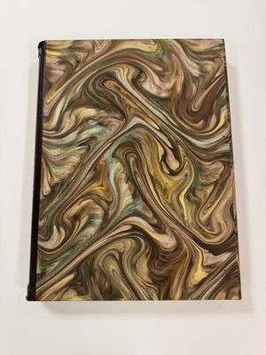 a close up of a notebook with a swirl design on it