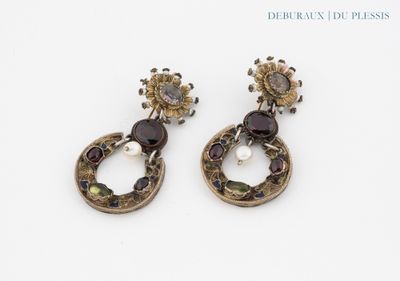 paire de boucles d'oreilles ornées de grenats et de perles sur un fond blanc