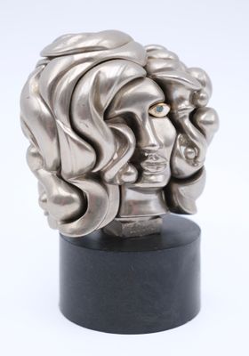 a silver sculpture of a woman ' s head on a black stand