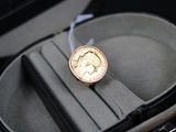 a gold coin in a case with a ribbon around it