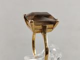 a close up of a gold ring with a smoky quartz stone