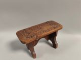 un petit banc en bois orné d'un motif sculpté