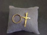 une bague en or et une croix posées sur un oreiller