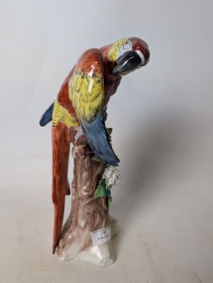 a figurine of a parrot sitting on a tree stump
