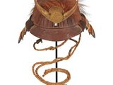 un vieux casque orné de cornes et de plumes est posé sur un socle