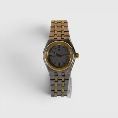 l'image d'une montre en or et noir sur une surface blanche