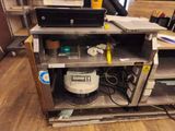 a computer and printer sitting on a shelf in a room