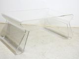 a pair of clear acrylic tables on a white floor