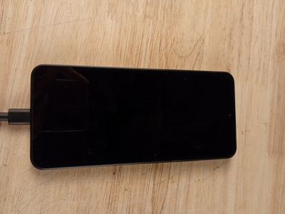 un téléphone portable branché à un chargeur posé sur une table