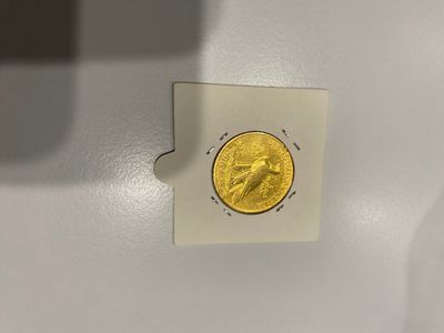 un petit bout de papier sur lequel se trouve une pièce d'or