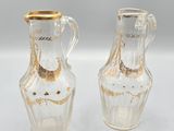 pair of clear glass vases with gold rims on a white surface