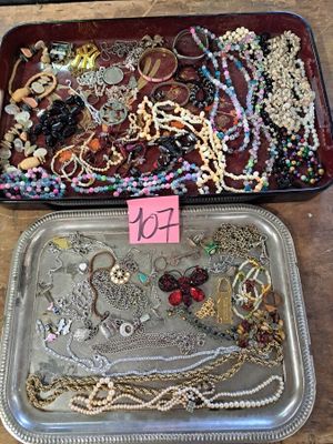 two trays of jewelry on a table with a price tag