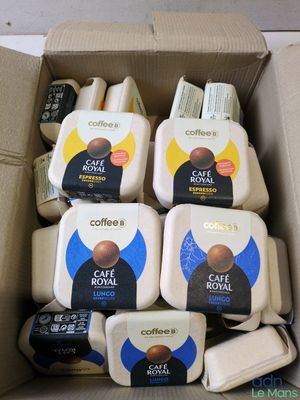 une boîte remplie de café et de crèmes posée sur une table