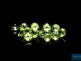 a close up of a group of green gems on a black surface