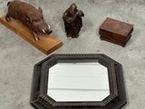 une photo d'un miroir, une statue représentant un sanglier et une statue représentant un homme