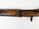 an old knife with a leather sheath hanging on a wall