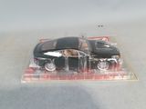 a black toy car in a clear box on a table