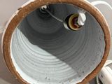 une image représentant un vase blanc et marron auquel est branché un cordon d'alimentation