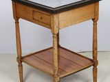 une petite table en bois avec un plateau en marbre, posée sur un sol blanc
