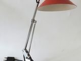 an image of a red and black desk lamp on a white surface