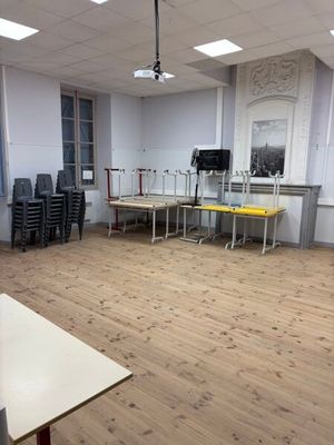 une pièce équipée de tables, de chaises et d'une télévision