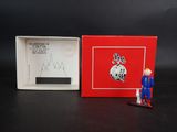 une image représentant une petite figurine d'homme dans une boîte rouge