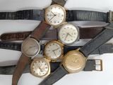 several different types of watches are arranged on a white surface