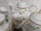 de nombreuses tasses, soucoupes et théières sur la table