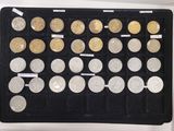 an assortment of silver and gold coins in a display case