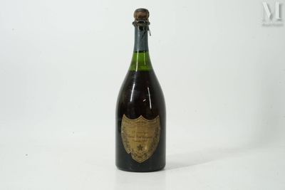 an old bottle of champagne sitting on top of a white table