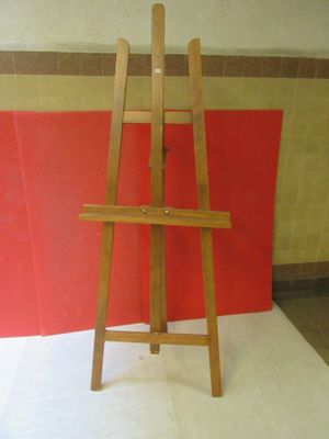 a wooden easel sitting on a white surface