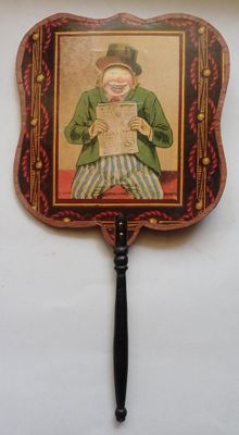 un vieux ventilateur orné d'une peinture représentant un homme tenant un journal