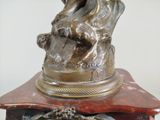 a bronze statue of a man sitting on top of a table