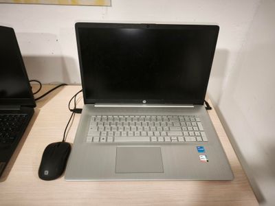 un ordinateur portable posé sur un bureau, à côté d'une souris