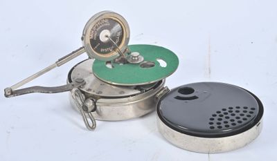 une casserole en argent avec un couvercle vert et un couvercle noir