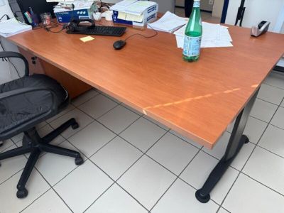 a desk with a bottle of water and a computer on it