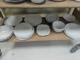 many plates and bowls sitting on a shelf in a room