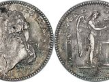 a silver coin with an image of a man and a woman on it