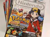 a stack of nintendo magazine covers sitting on a table
