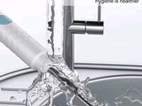 someone is using a toothbrush to clean their teeth in the sink