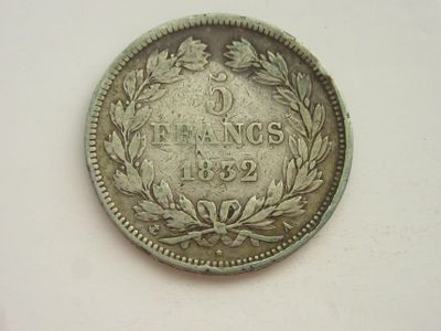 une vieille pièce d'argent ornée d'une couronne de feuilles