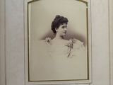 an old photo of a woman in a white dress with a flower in her hair