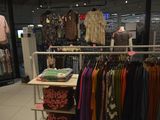 a rack of clothes in a clothing store with clothes on it