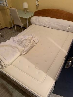 un lit avec un matelas et une table dans la chambre