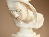 statue of a woman with a hat on her head on a pedestal