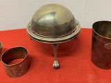 three cups and a silver plate on a red cloth